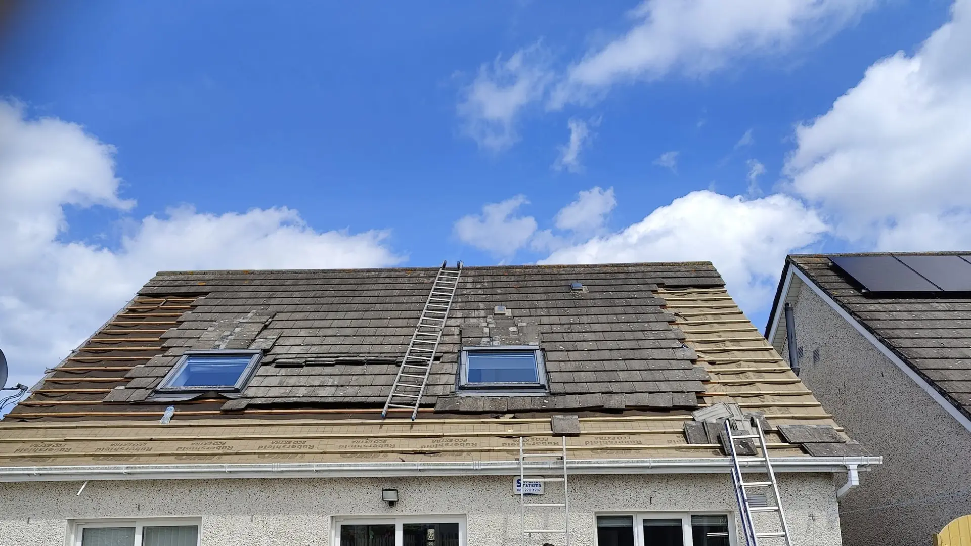 Roofer sealing roof ridge on residential house — roof repair and maintenance